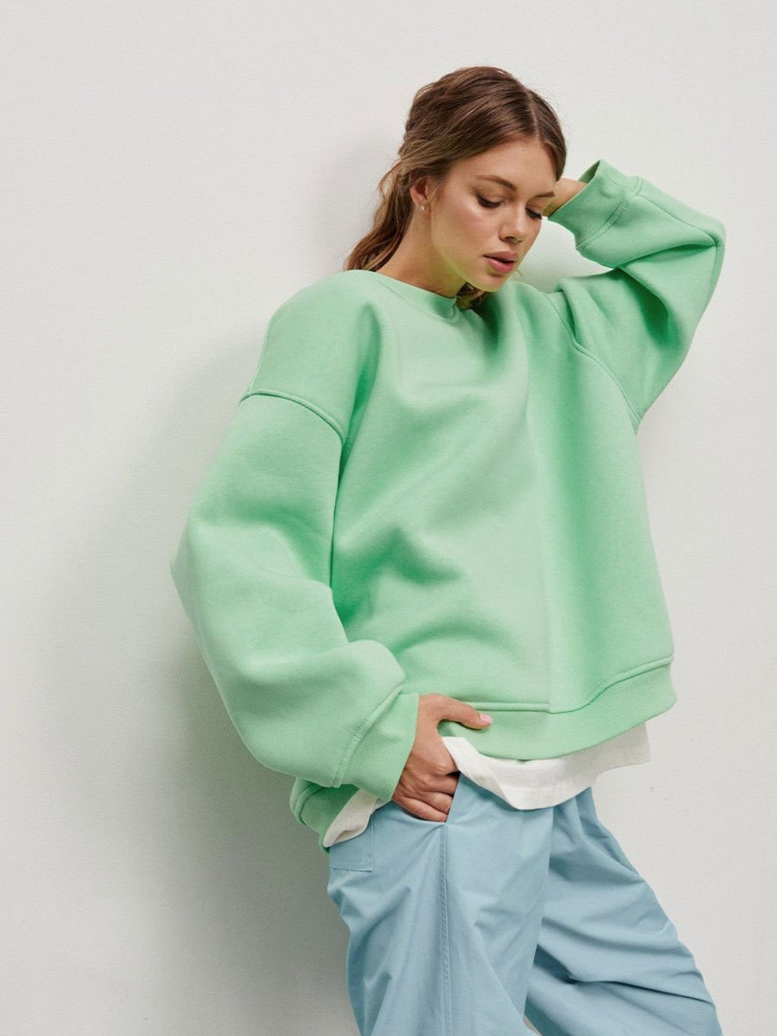 woman wearing oversized cabin sweatshirt in mint green