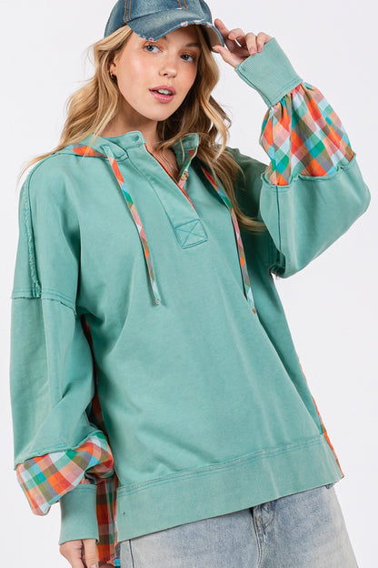 woman wearing plaid print hoodie in eucalyptus green