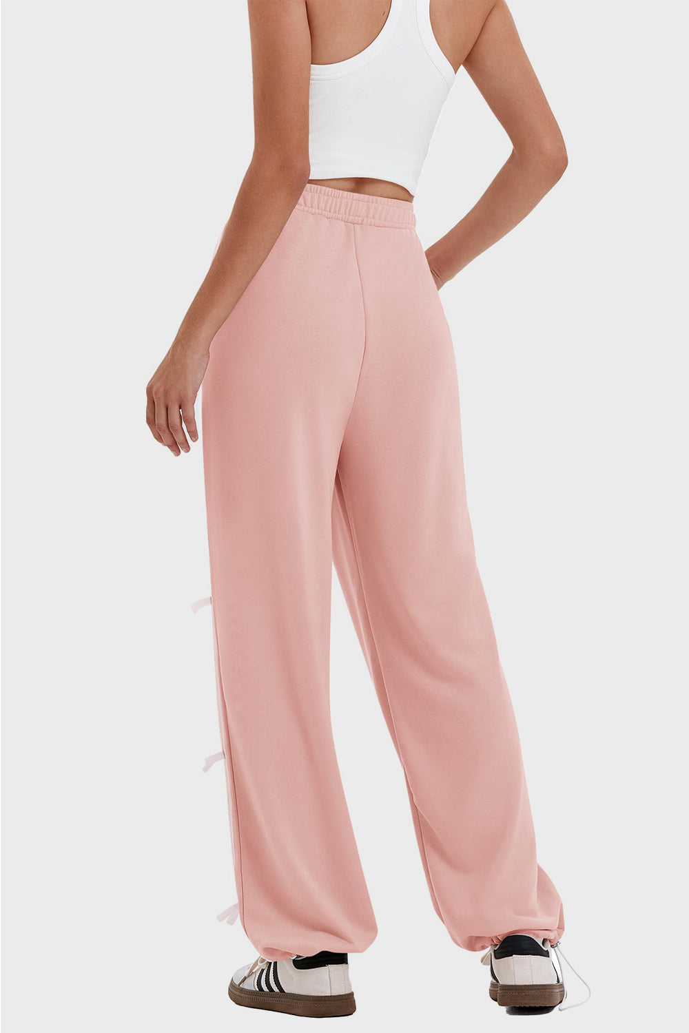 woman wearing bow striped track pants in pink