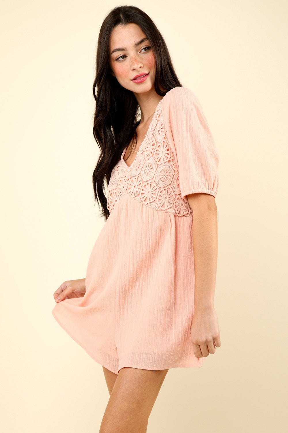 woman wearing pink lace romper side view