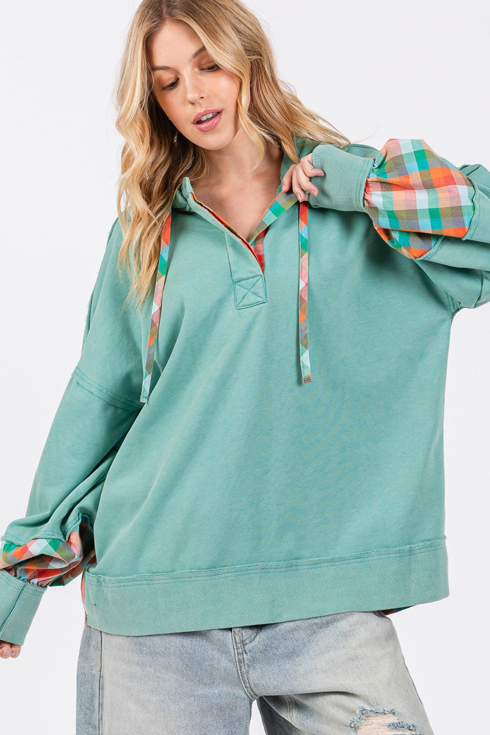 woman wearing plaid print hoodie in eucalyptus green