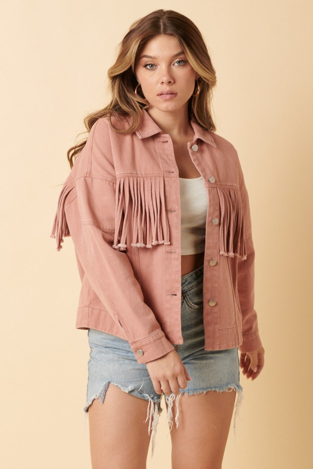 woman wearing western fringe jacket in blush pink