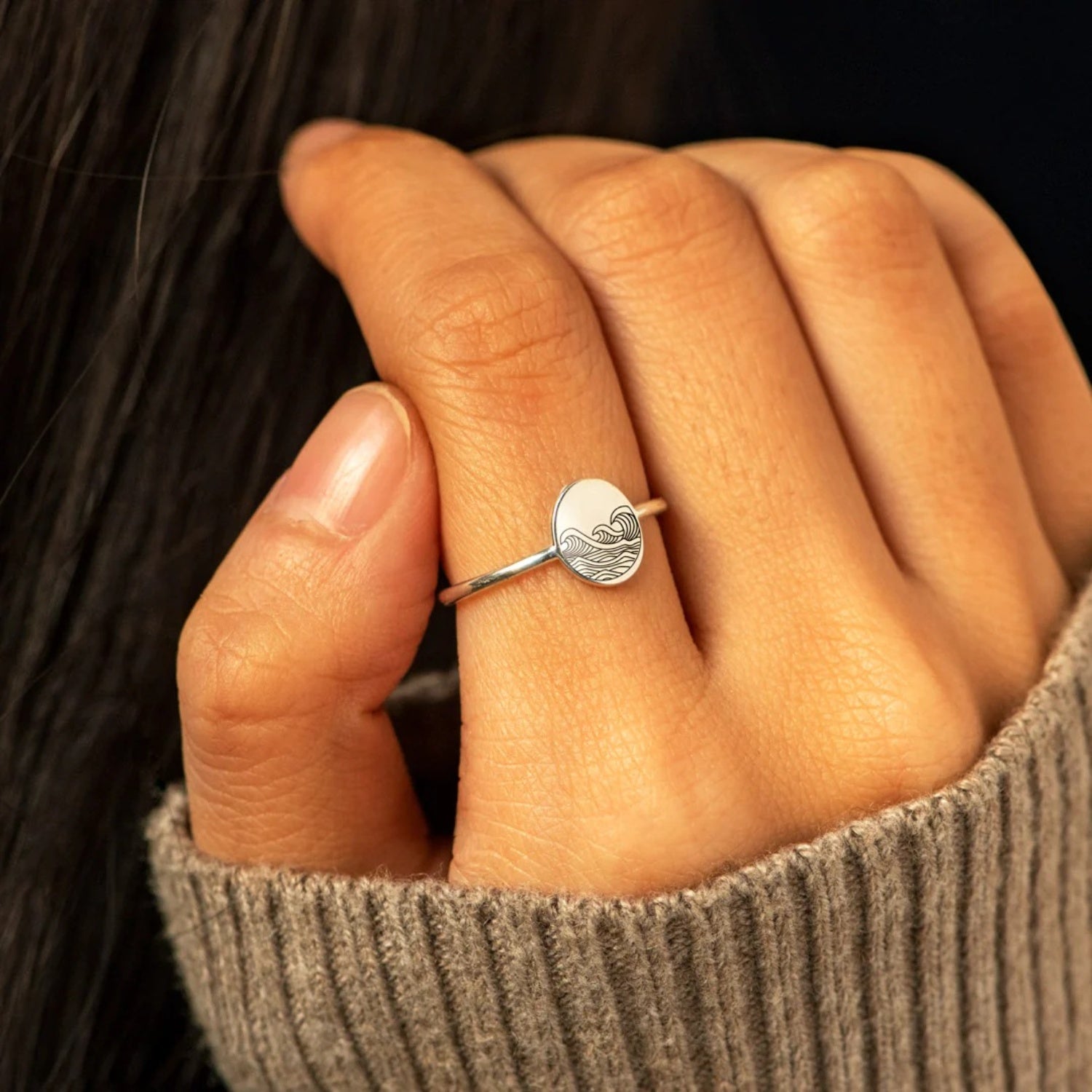 woman's hand wearing the water wave signet ring sterling silver