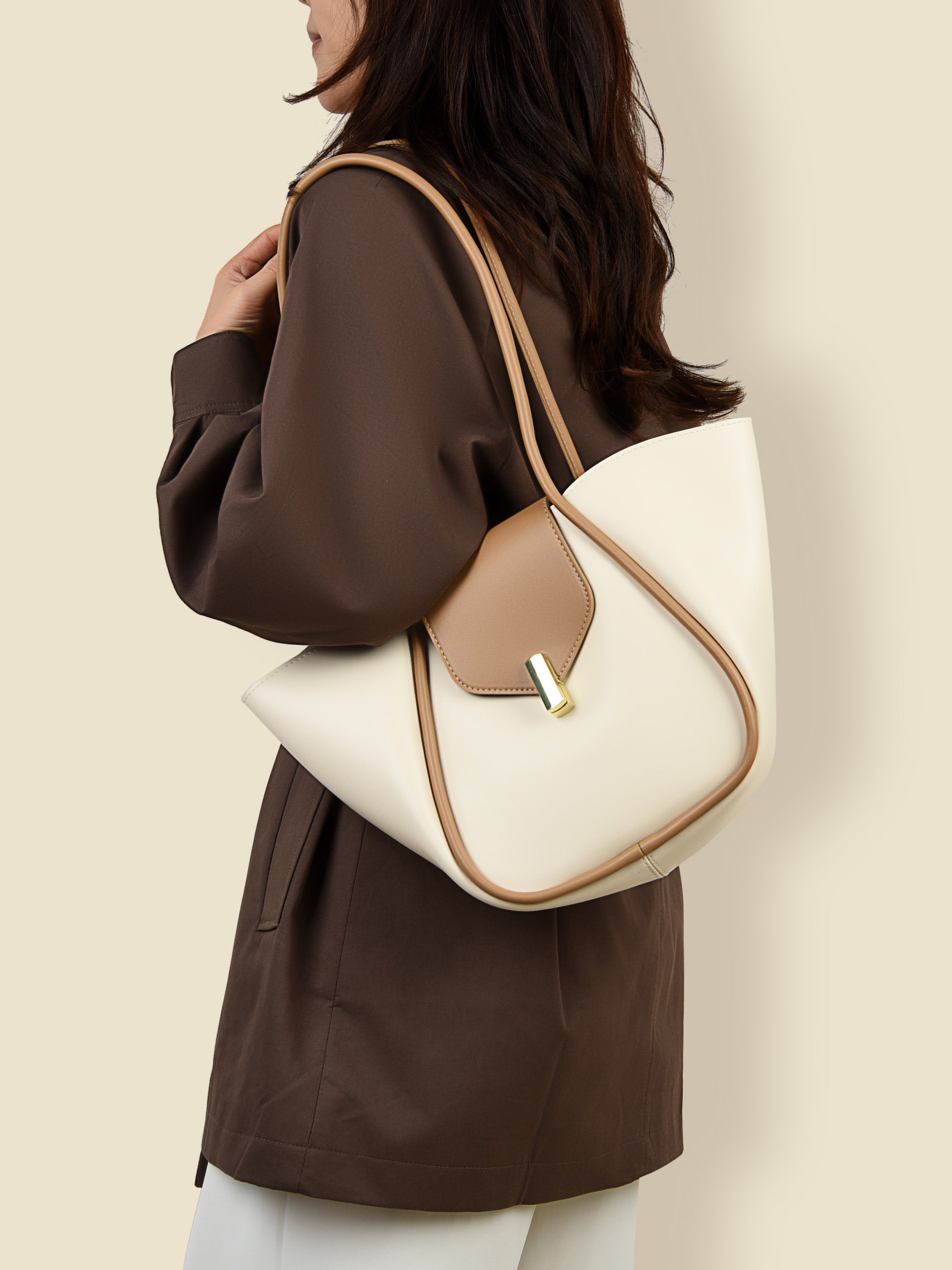 woman wearing shoulder bag with removable pouch in cream and tan