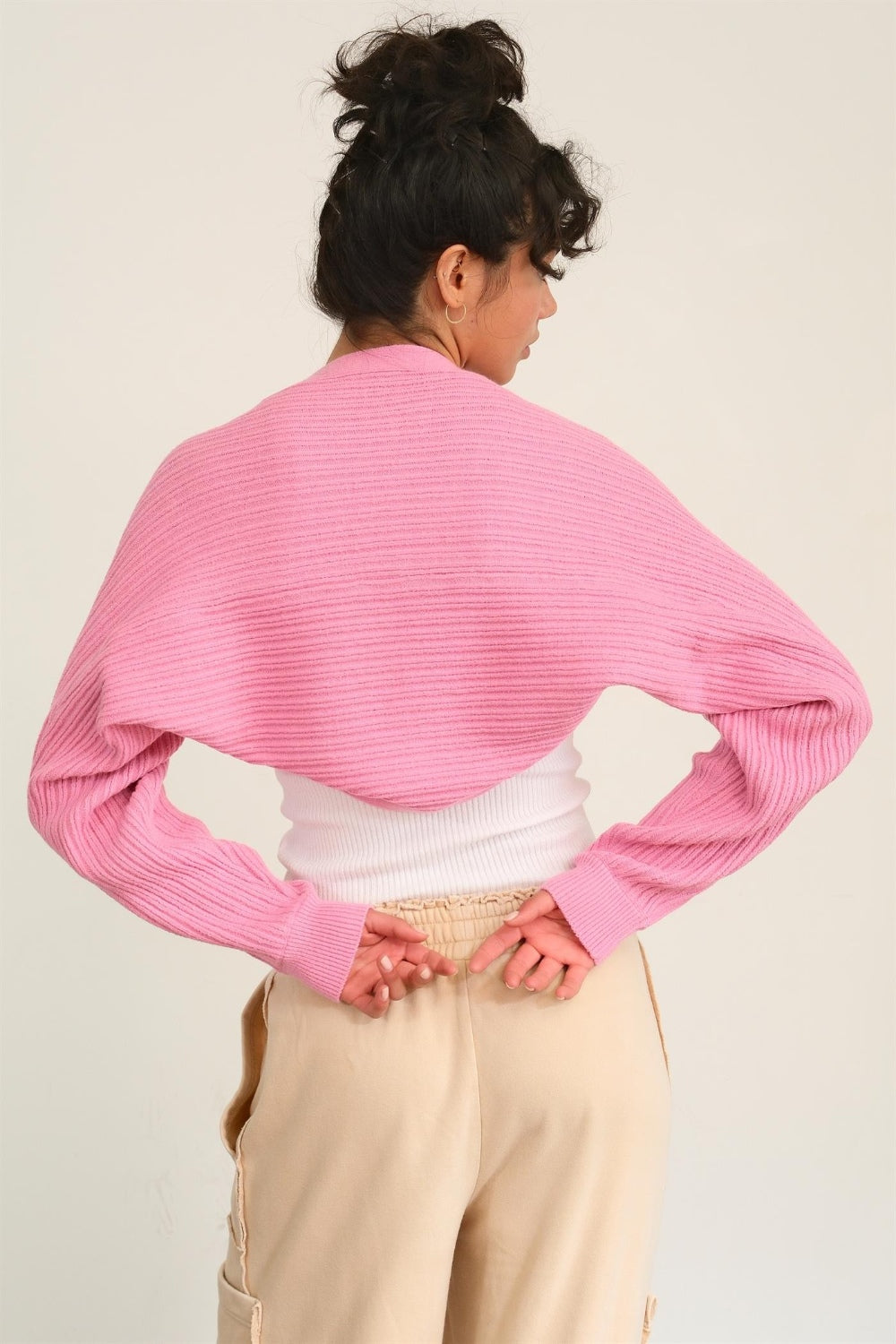 woman wearing bolero cardigan in pink back view