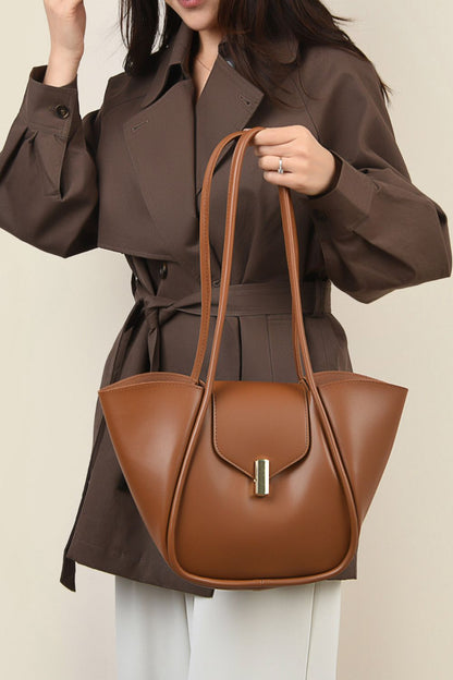 woman holding shoulder bag with removable pouch in cognac